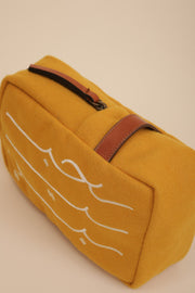Pochette en drap de laine doublé, couleur jaune, avec anse en cuire camel. Calligraphie 'Habibi' ('Mon Amour' en arabe) brodée sur le devant.