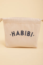 Découvrez la petite pochette à coulisse by LYOUM avec notre message 'Habibi' ('Mon Amour' en arabe) brodé sur un côté, en fil bleu navy.