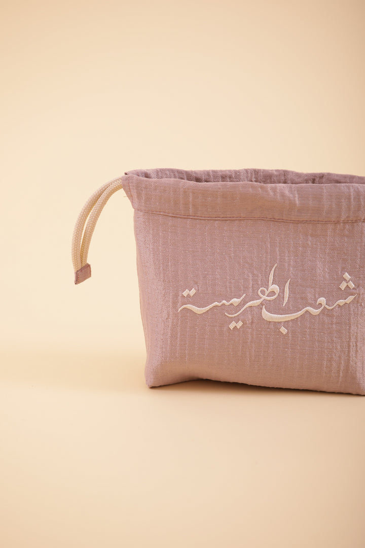 Pochette à cordant avec broderie 'Peuple de la Harissa' en arabe sur un côté.