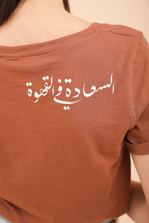 Elégante calligraphie 'Le bonheur est dans le café' derrière l'épaule.