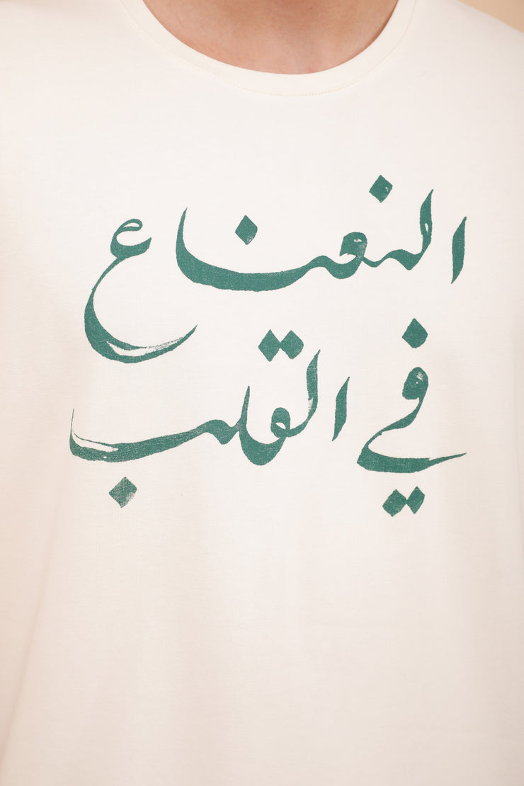 Sérigraphie : 'La menthe dans le coeur' en calligraphie arabe sur le devant.