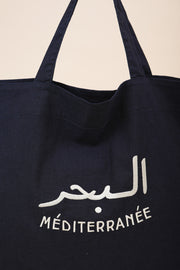 Maxi sac de plage en denim bleu foncé by LYOUM avec petite poche intérieure. Broderie 'La Mer Méditerranée' en arabe/français, en fil écru.