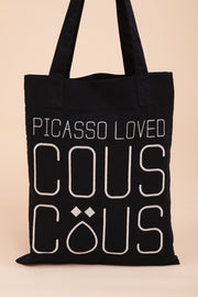 Tote bag en toile bleu navy avec broderie 'Picasso Loved Couscous' sur un côté.