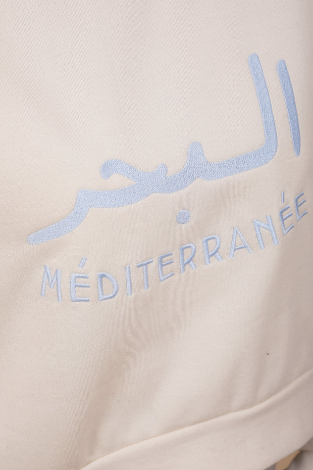 Broderie 'La Mer Méditerranée' en arabe et français sur le devant.