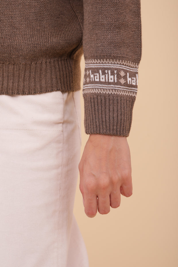 Craquez pour le nouveau motif et notre message iconique 'habibi' ('mon amour' en arabe) délicatement délicatement tricotés au niveau de la manche.