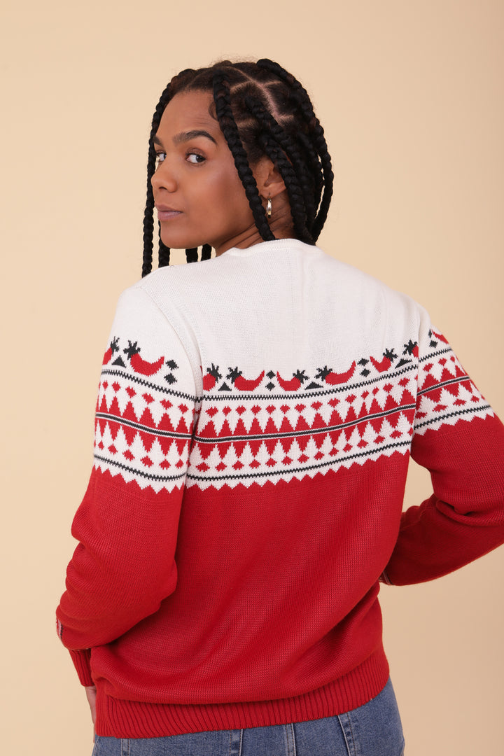 Femme à tresse vue de dos portant le pull de Noël LYOUM rouge motif piments.