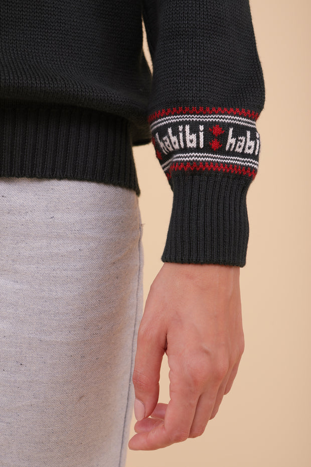 Tombez sous le charme du nouveau pull de Noël pour femme avec notre message iconique 'habibi' ('mon amour' en arabe) délicatement tricoté au niveau de la manche.