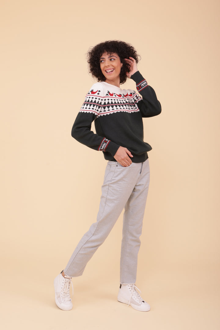 Femme en pull de Noël LYOUM et jeans gris clair.