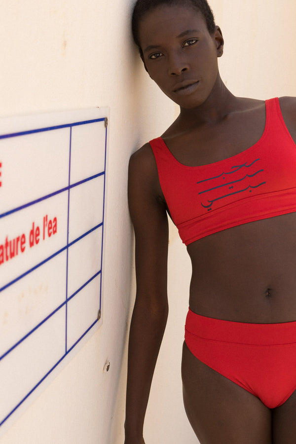 Maillot deux-pièces LYOUM pour femme, stylé et facile à porter. Brassière au col rond et bas de maillot à la taille haute. Calligraphie Habibi en arabe sur le haut. Photo de face.