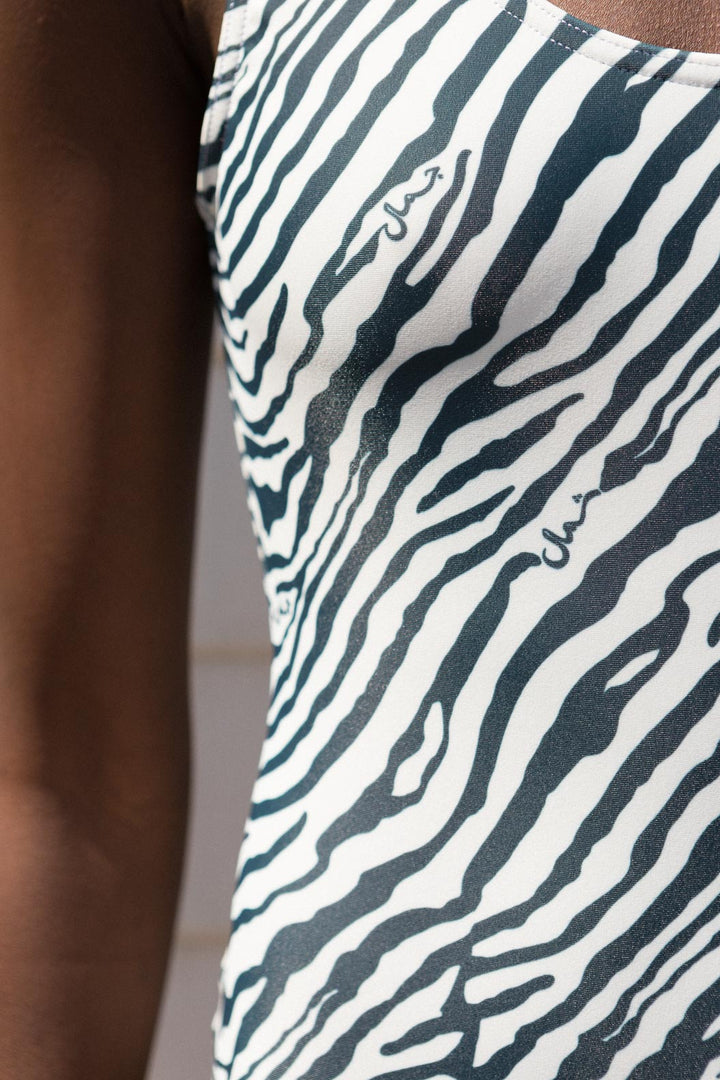 Maillot de bain LYOUM pour femme chic et élégant. Imprimé zébré blanc et bleu navy avec trois petits mots 'Nord' 'Sud' et 'Beauté' en calligraphie arabe dissimulés dans les zébrures.  Photo zoom sur les petits mots.