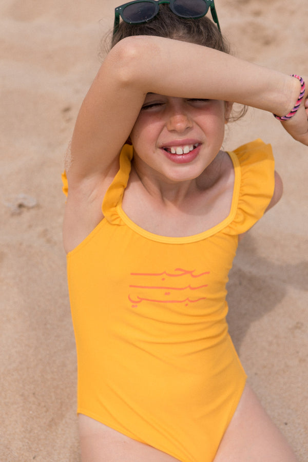 Maillot une-pièce LYOUM pour enfant, adorable et confortable. Calligraphie Habibi en arabe sur le devant. Photo de face.